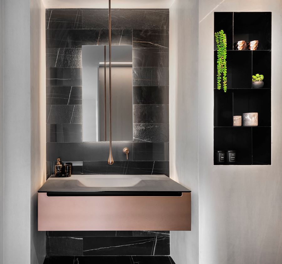 Penthouse - TLV כיור והמראה בחדר האמבטיה מואר בגופי תאורה מיוחדים על ידי קמחי תאורה